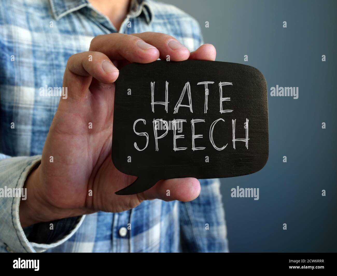 Hate speech concept. A hand holds a black plate. Stock Photo