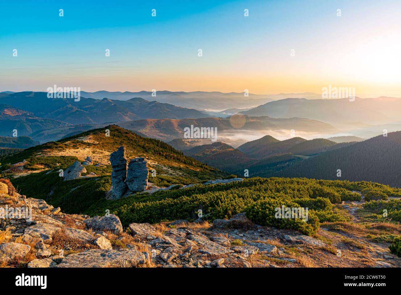 Amazing sunrise high in the mountains. Autumn morning at the mountain top. Social distancing at its best. Stock Photo