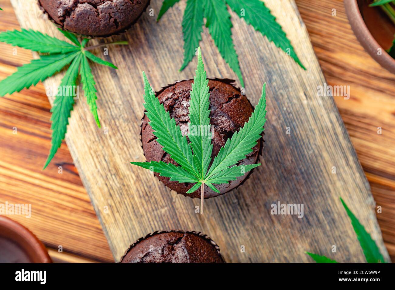 Cupcake with marijuana. Chocolate cupcake muffins with cannabis weed cbd. Medical marijuana hemp drugs in food dessert, ganja legalization. Cooking Stock Photo