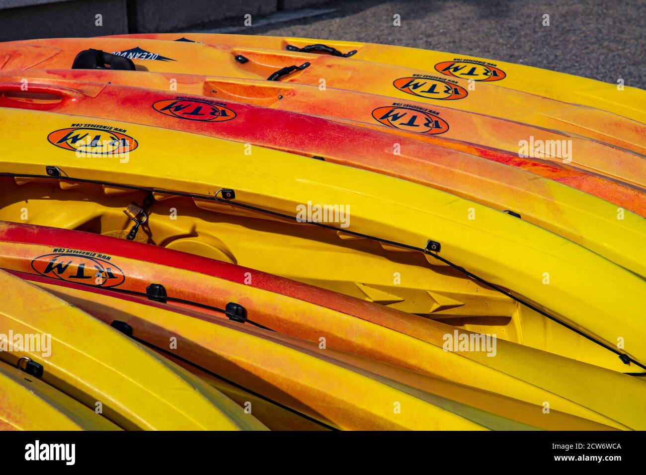 Rental sit on top kayaks lined up ready for hire on a beach in Llanca on the Costa Brava, Spain Stock Photo