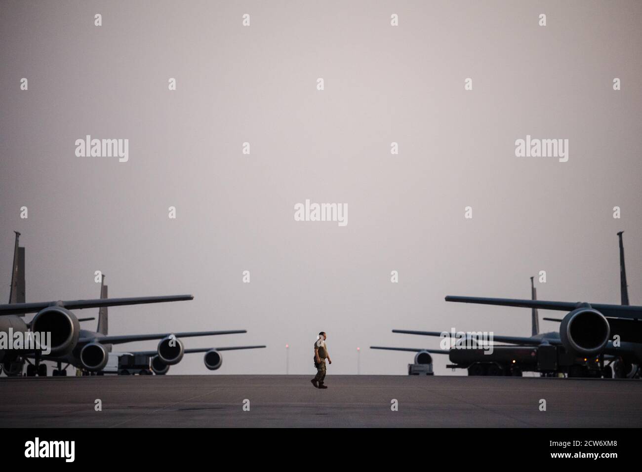 A U.S. Air Force Airman with the 379th Expeditionary Aircraft Maintenance Squadron walks across the flight line at Al Udeid Air Base, Qatar, Sept. 18, 2020. The 379th EAMXS provides support to aircraft like the KC-135 Stratotanker, enabling the 379th Air Expeditionary Wing to deliver air power throughout the U.S. Air Forces Central area of responsibility. (U.S. Air Force photo by Staff Sgt. Lauren Parsons) Stock Photo