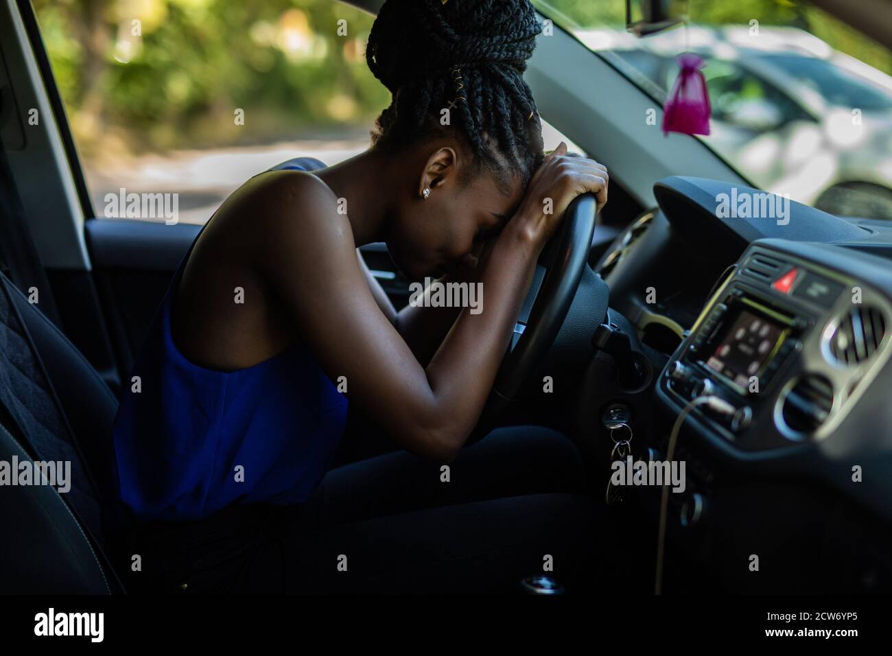 Tired young woman driver asleep on pillow on steering wheel, resting after  long hours driving a car. Fatigue. Sleep deprivation Stock Photo - Alamy