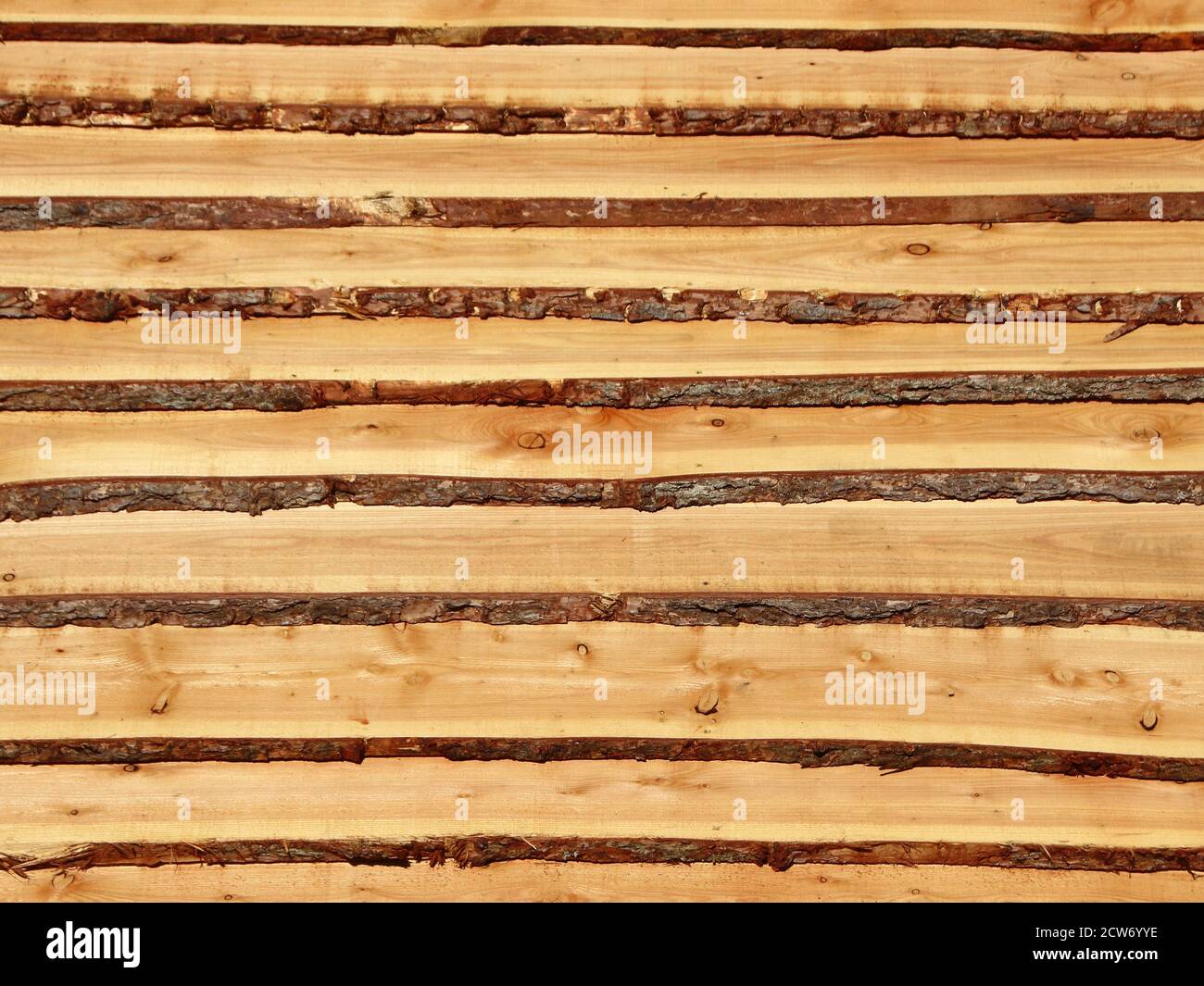 Rough wooden pine planks with bark on the side. It resembles a set of stairs. Stock Photo