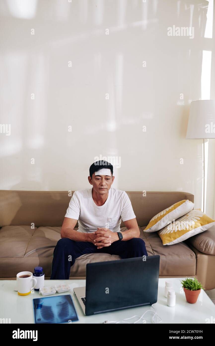 Man with fever vodeo calling doctor Stock Photo