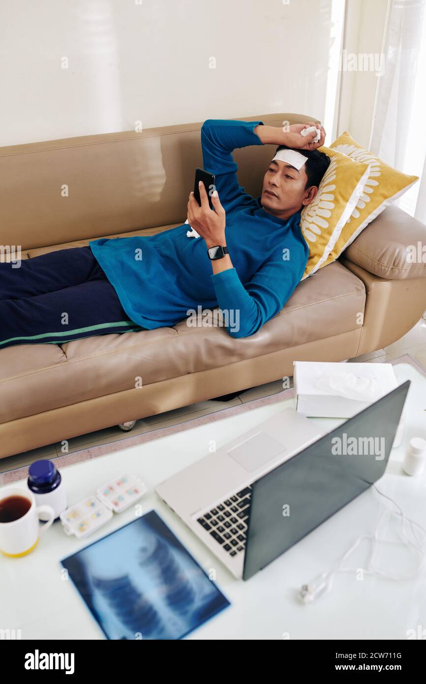 Sick man resting on sofa Stock Photo