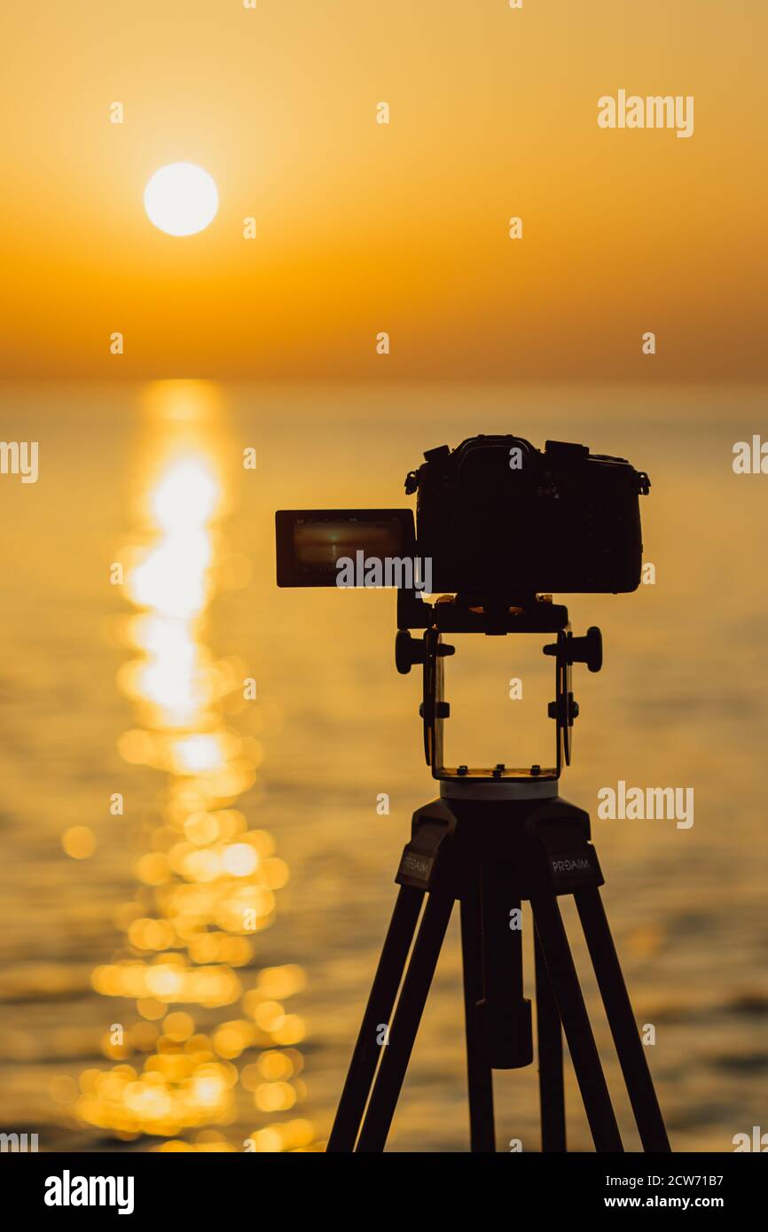 The camera stands on a tripod and capture the sunset Stock Photo - Alamy