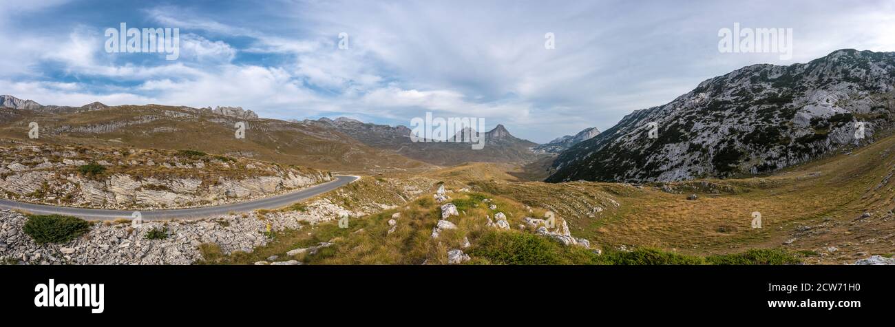 Beautiful panorama on top of Durmitor mountain. Serpentine road and unbelievable view to mountains of Montenegro. Lovely sky with clouds. Stock Photo