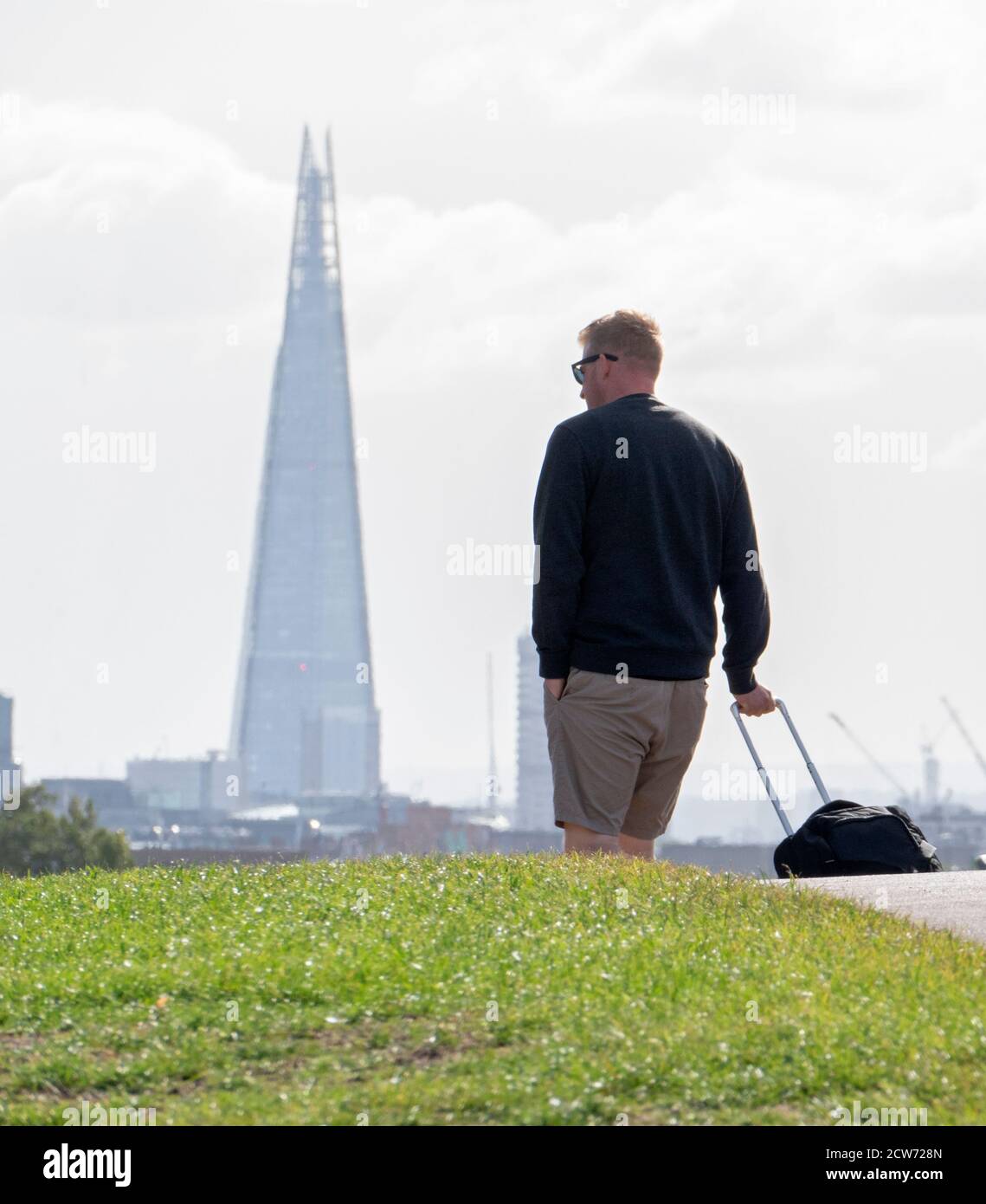 Tourists with their luggage pack up and leave the city with the Shard building on the city skyline. Possible Covid-19 Coronavirus 2nd wave lockdown fo Stock Photo