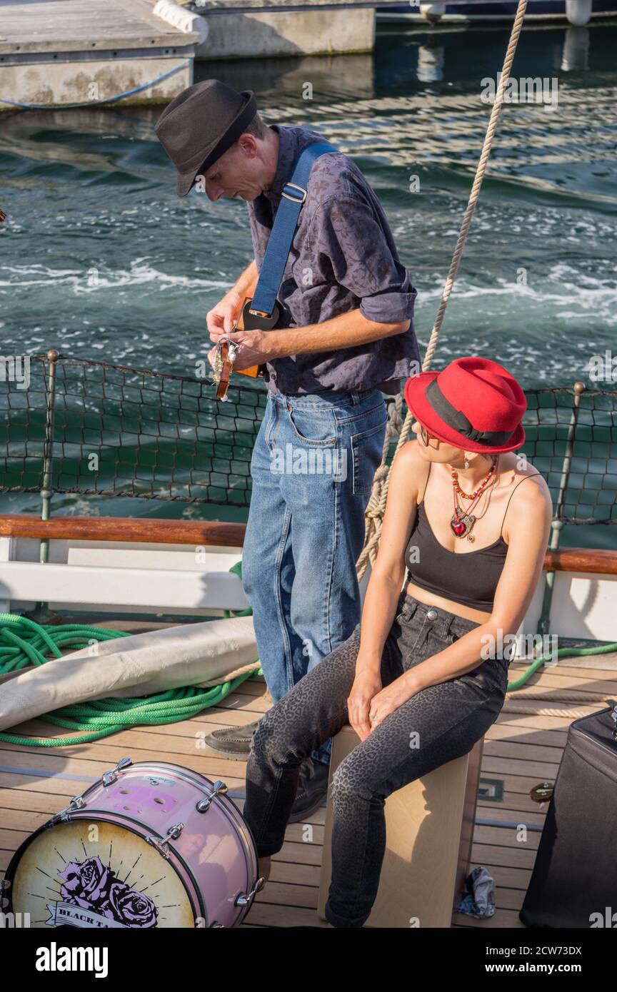 Group called The Black Tar Roses performing from the deck of a boat, a Bristol Pilot Cutter, called Olga, in Plymouth Barbican harbour. Stock Photo