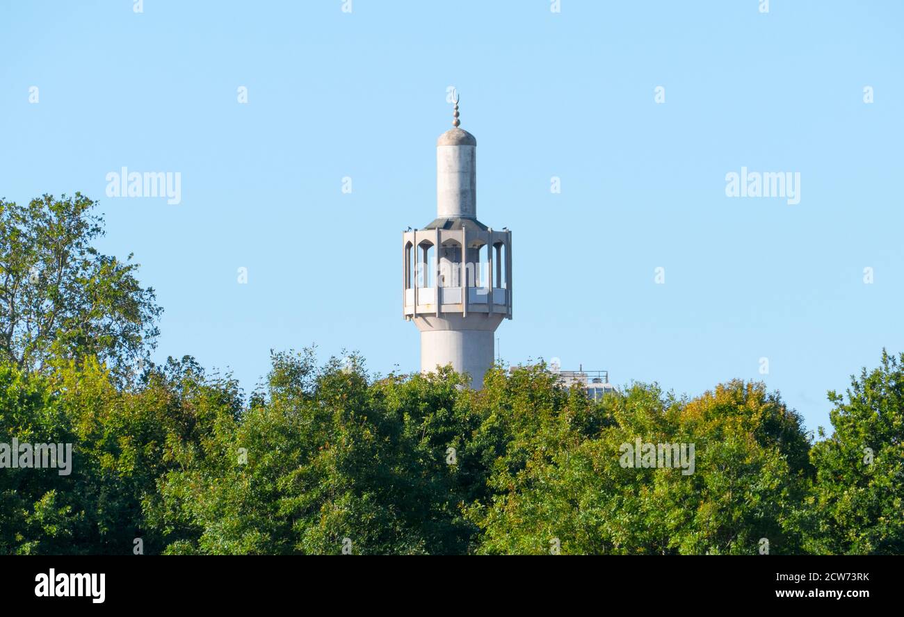 London Central Mosque or Regent's Park Mosque tower emerges above the tree line at Regents Park in London, England. It is a central place of Islamic w Stock Photo