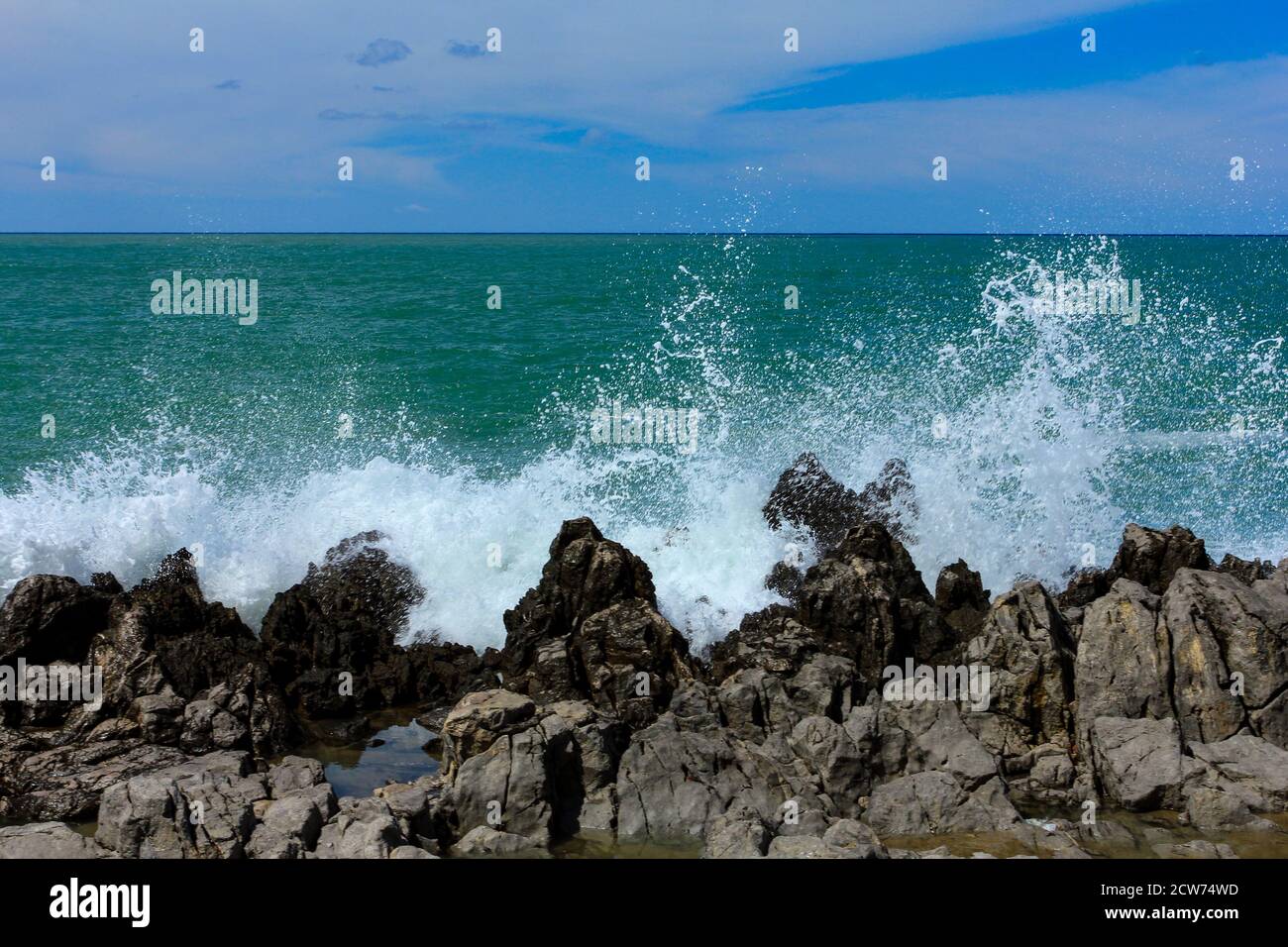 Sea waves crash and splash on rocks.  Stock Photo