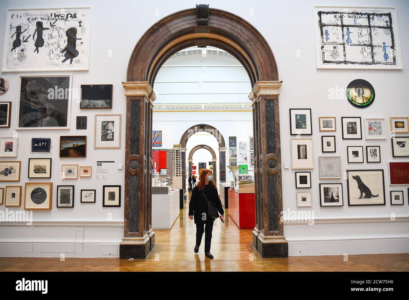 NOTE TO EDITORS. FOR USE IN RELATION TO THE EXHIBITION ONLY. A member of the public looks at various artworks at a preview for the 'summer' exhibition at the Royal Academy of Arts in London. The 252nd Summer Exhibition was postponed because of the coronavirus pandemic and will take place in the autumn for the first time. Stock Photo