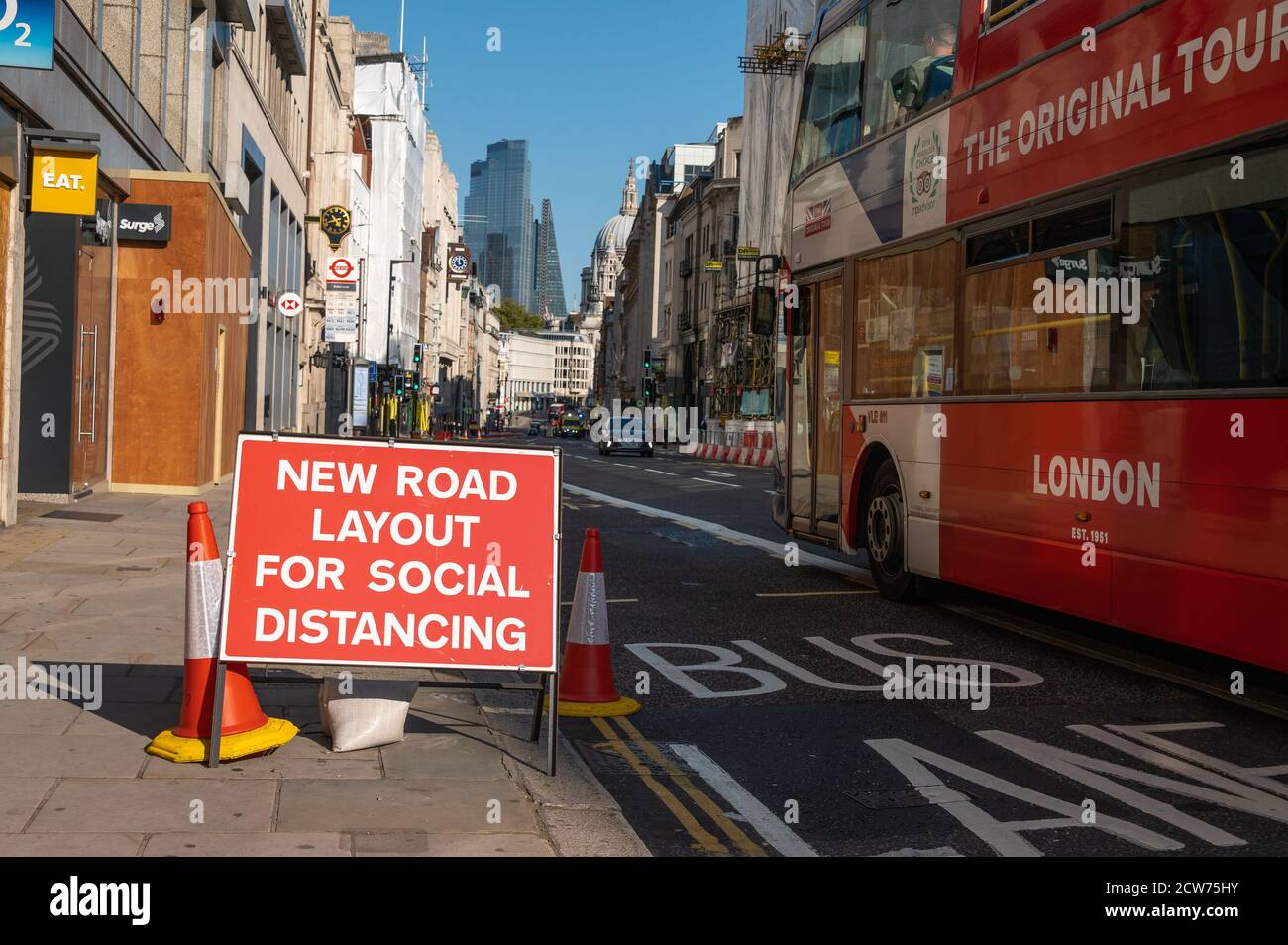 LONDON - SEPTEMBER 13, 2020: Social Distancing new road layouts sign with a London Double Decker Bus passing and St Paul's Cathedral in the background Stock Photo