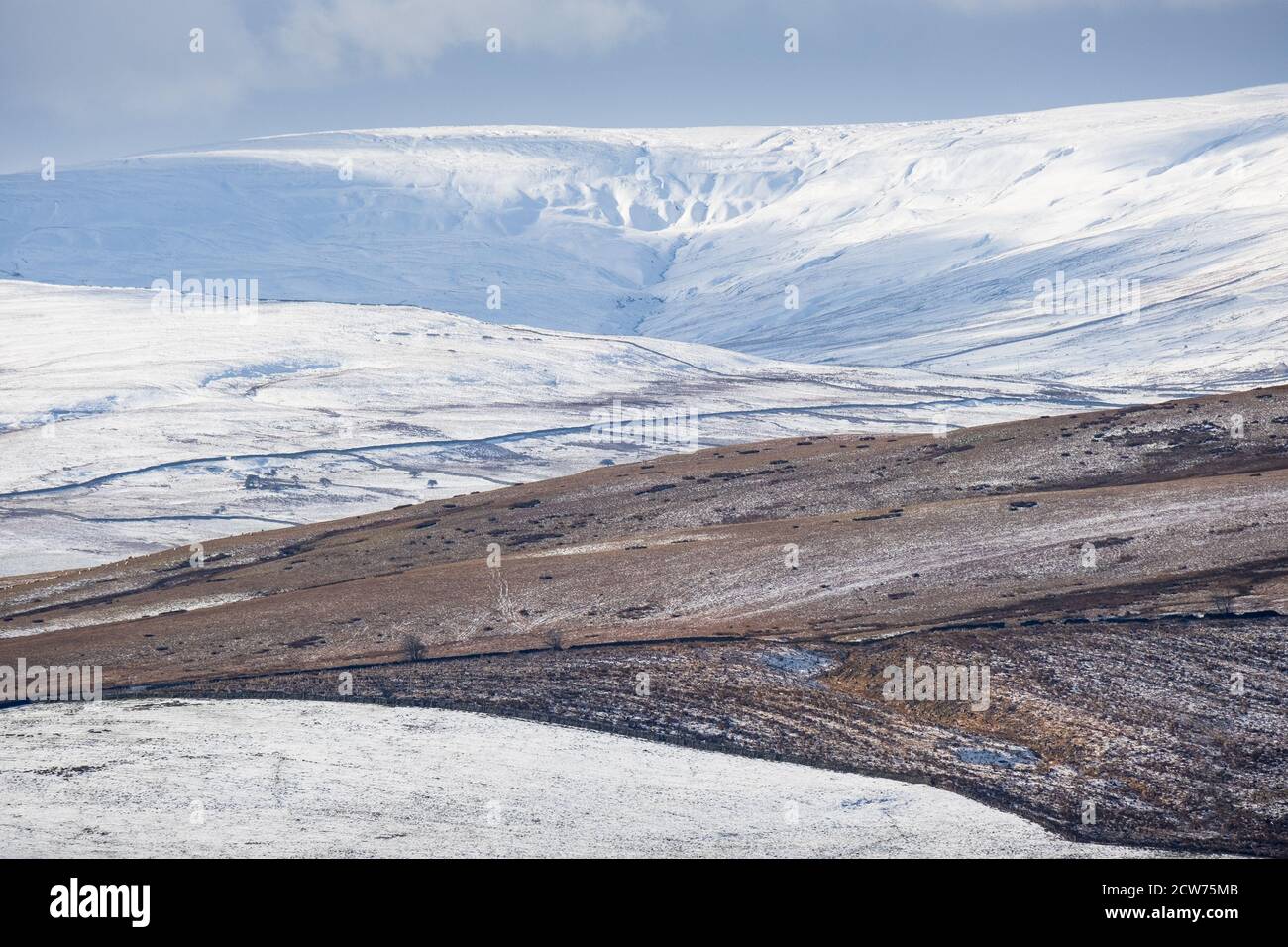 Snow on hills in the Northern Pennines above bleak deserted moors in winter. Stock Photo
