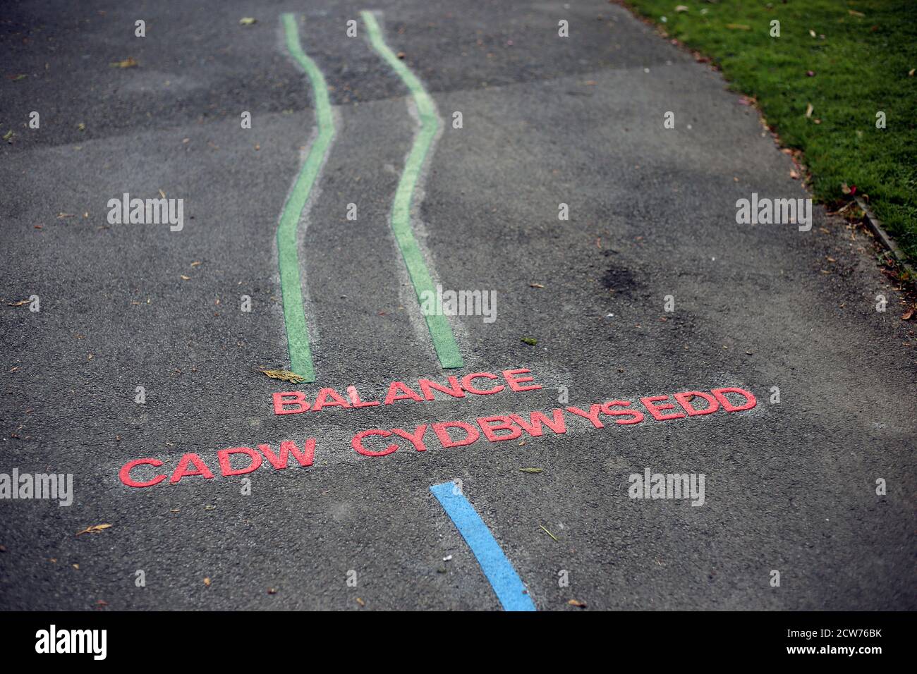 Exercise game for children painted in English and Welsh on a path in a park Stock Photo