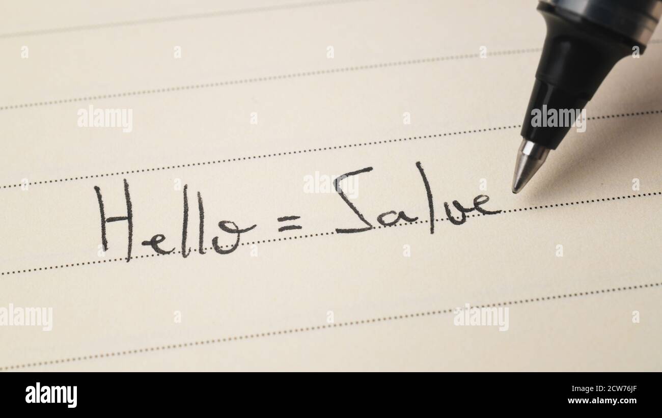 Beginner Italian language learner writing Hello formal word Salve for homework on a notebook macro shot Stock Photo