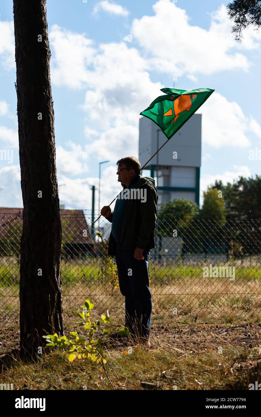 Gorleben, Germany. 28th Sep, 2020. Ulrich Sandvoß, opponent of nuclear power, stands with a flag in front of the former exploration mountain in Gorleben. According to the findings of the Federal Society for Final Disposal, 90 areas in Germany have favourable geological conditions for a nuclear waste repository. The Gorleben salt dome in Lower Saxony is not among them. Credit: Philipp Schulze/dpa/Alamy Live News Stock Photo