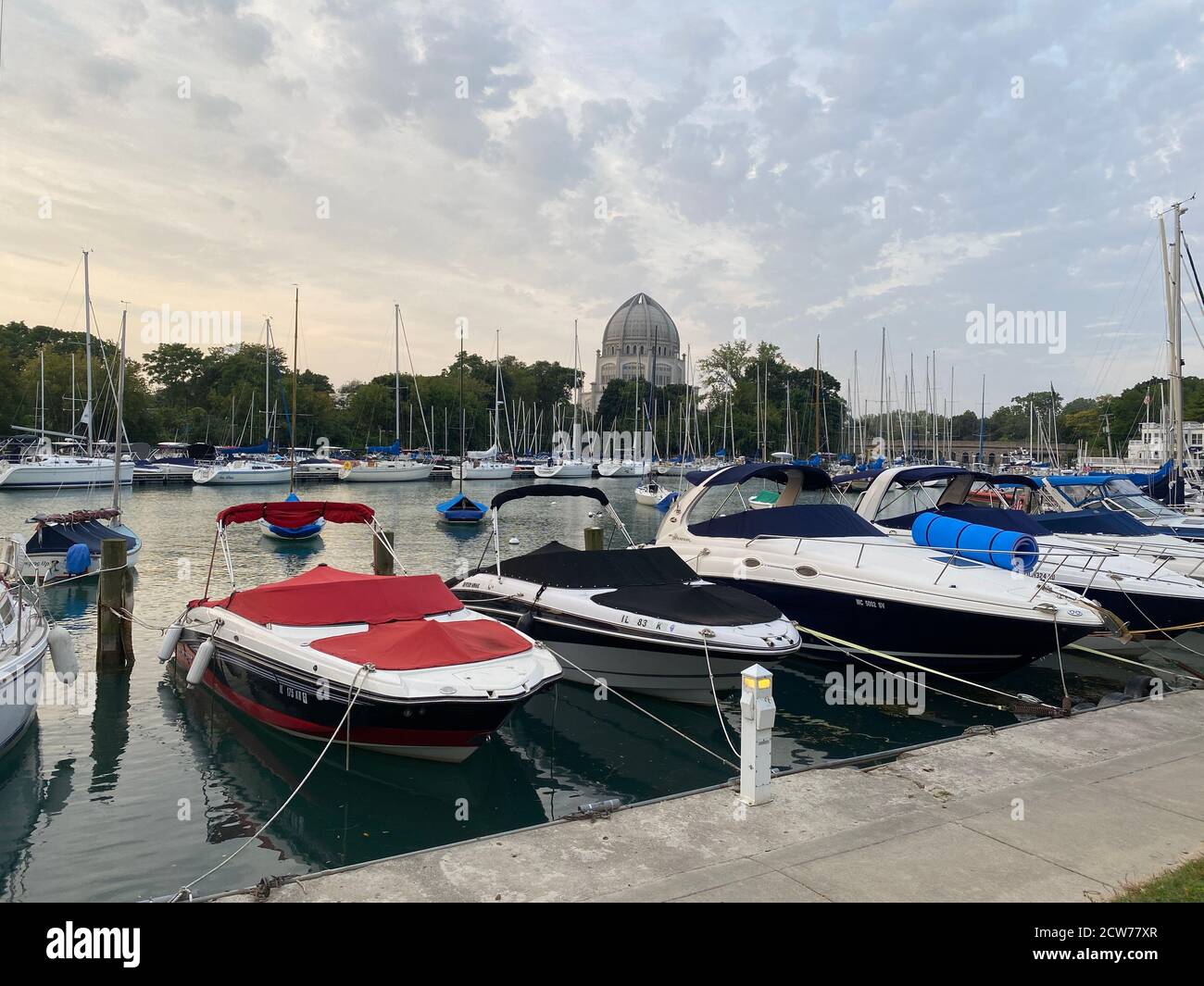 Boats docked in Wilmette Harbor on Lake Michigan with the Baha'i House of Worship in the background Stock Photo