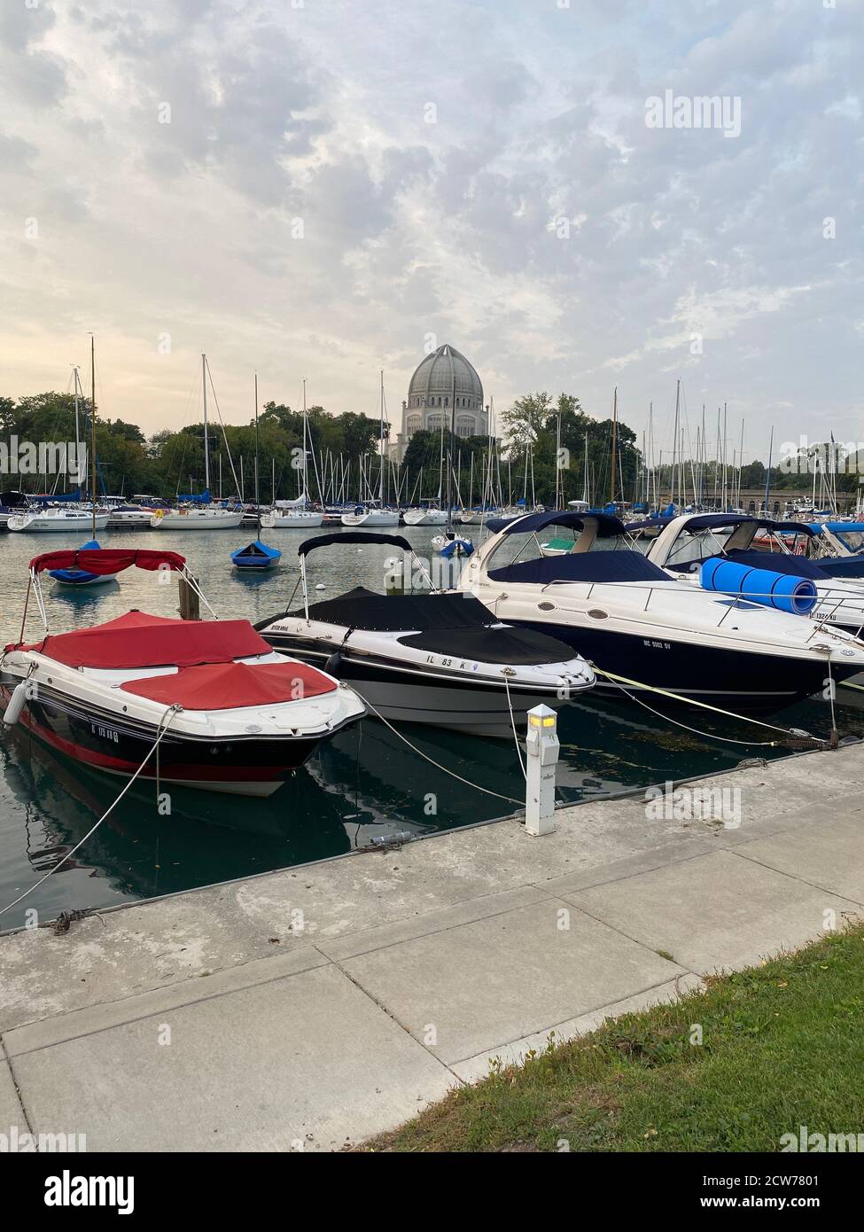 Boats docked in Wilmette Harbor on Lake Michigan with the Baha'i House of Worship in the background Stock Photo