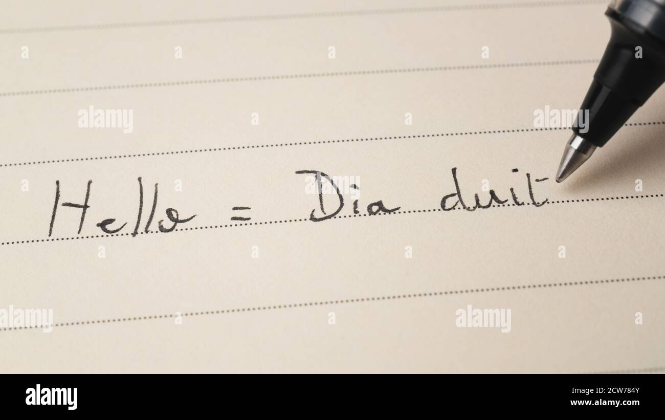 Beginner Irish Gaelic language learner writing Hello word Dia duit for homework on a notebook macro shot Stock Photo