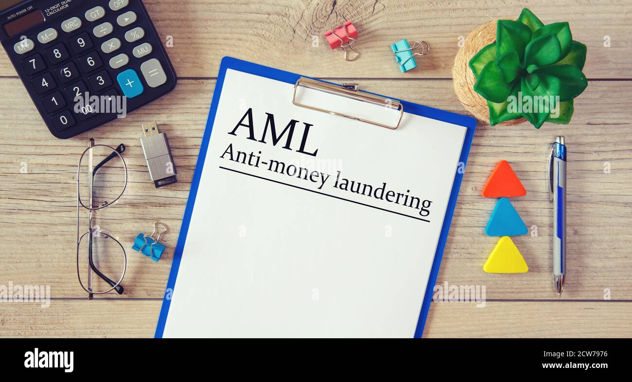 Paper with Anti-money laundering AML on the table, calculator and glasses Stock Photo