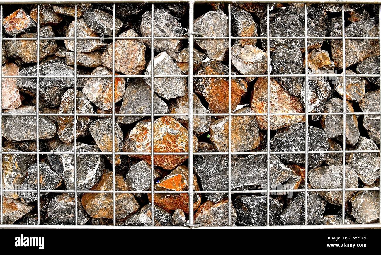 A steel cage of randomly shaped and coloured rocks Stock Photo Alamy