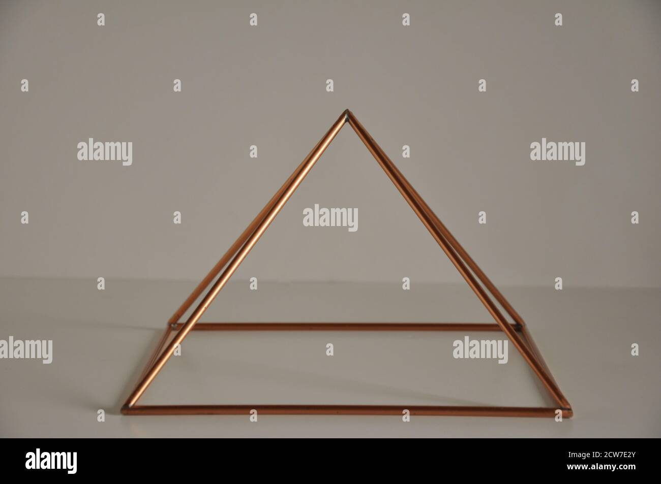 Copper pyramid. cast copper pyramid on white background, white