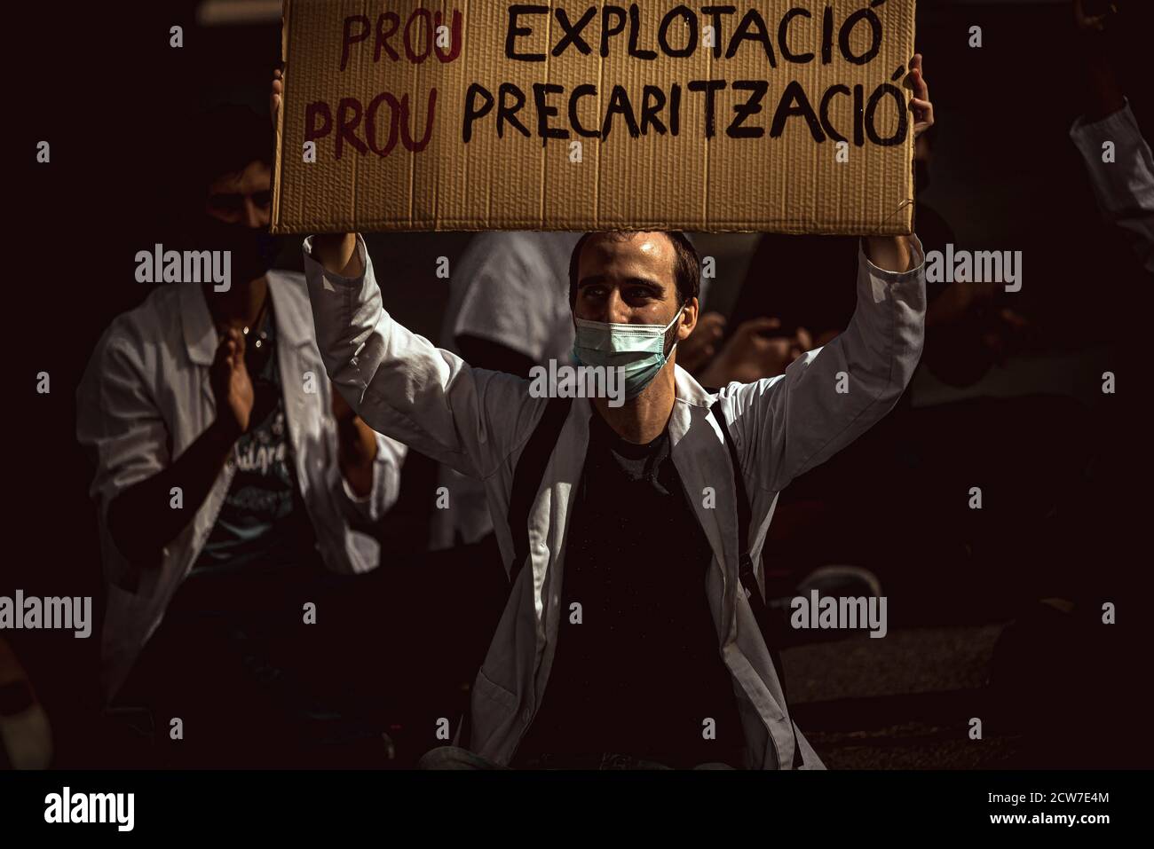 Barcelona, Spain. 28th Sep, 2020. A young resident doctor holds a placard reading 'stop exploitation, stop precariousness' as he protests over precarious conditions during their postgraduate training specializing in the health care system due to low wages, high number of working hours and lack of monitoring. Credit: Matthias Oesterle/Alamy Live News Stock Photo