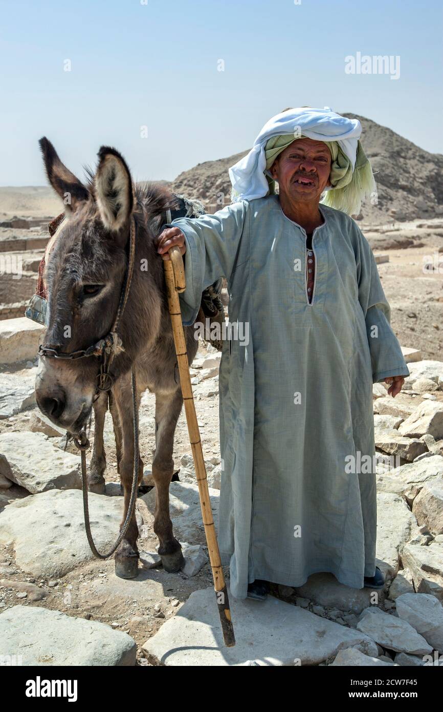 An Egyptian man and his donkey pose for photos at the Saqqara Necropolis near the Step Pyramid at Saqqara in northern Egypt. Stock Photo