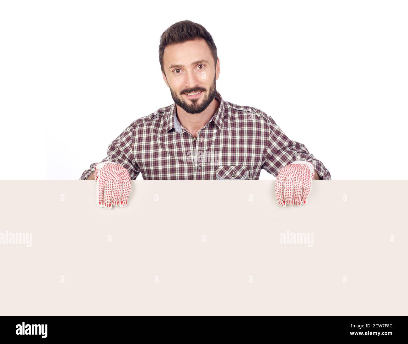 Cheerful handyman holding a blank board, white background Stock Photo