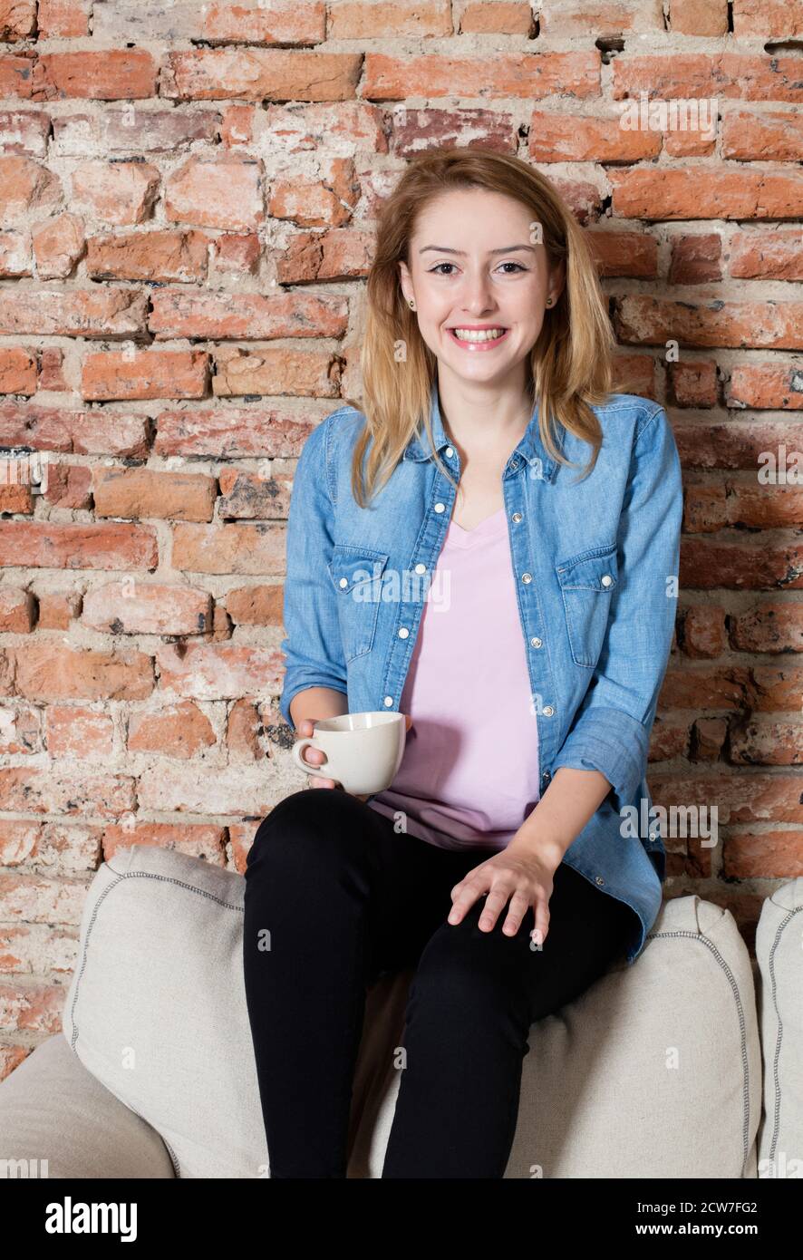 Smiling woman having a coffee Stock Photo
