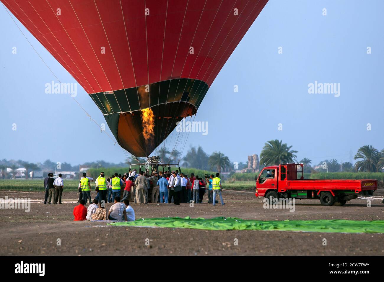 A flame burns as a hot air balloon prepares for lift-off at sunrise at Luxor in Egypt. The balloon will then fly over the Nile River and ancient sites Stock Photo