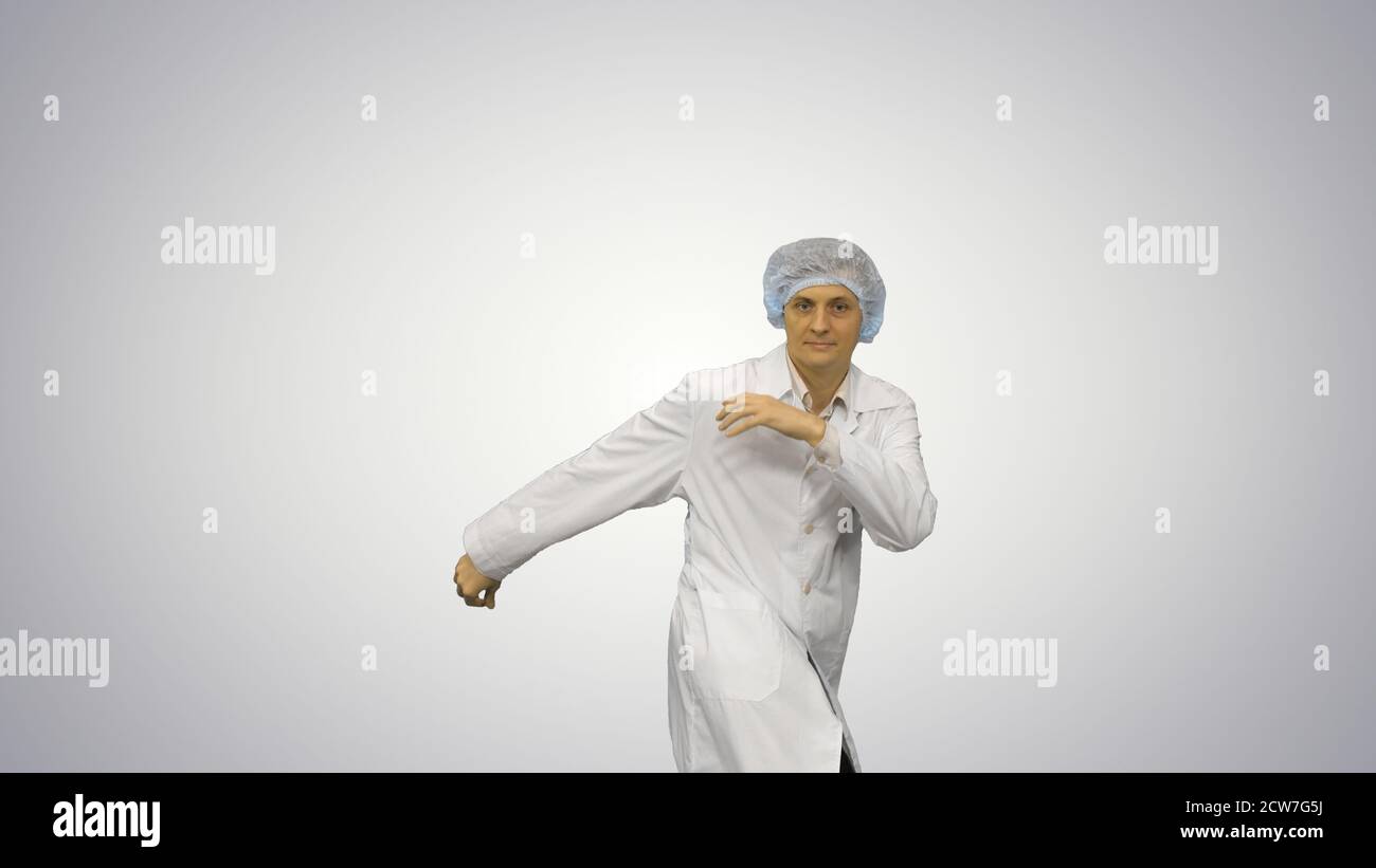 Young male doctor in white robe and protective cap dancing moder Stock Photo