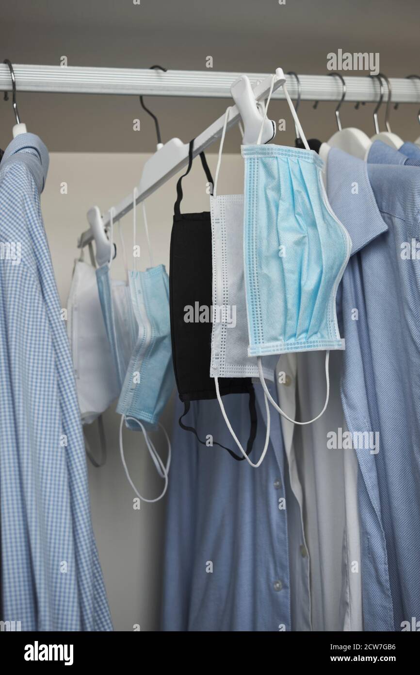 Different protective face masks hanging  with clothes Stock Photo