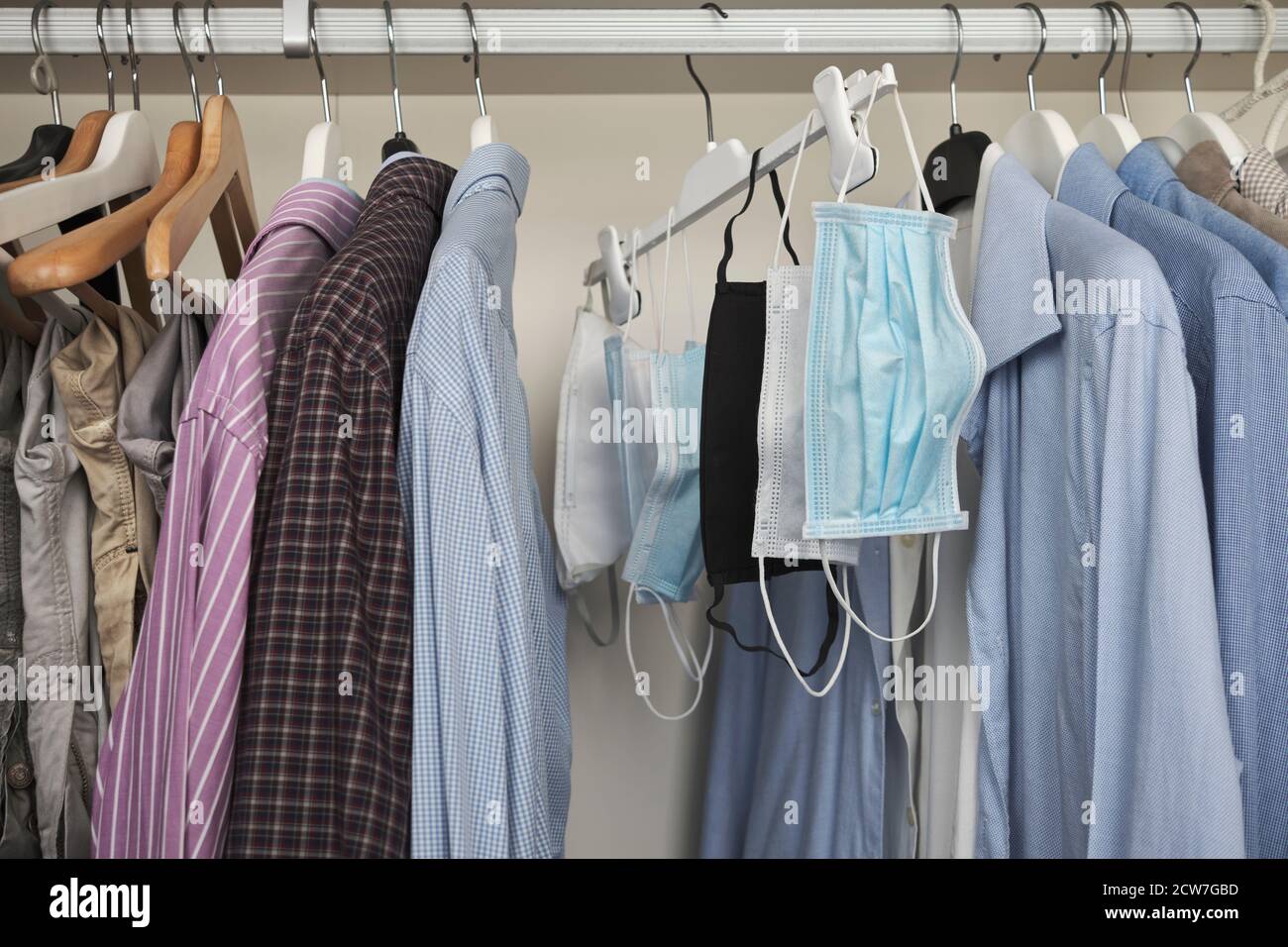 Different protective face masks hanging  with clothes Stock Photo