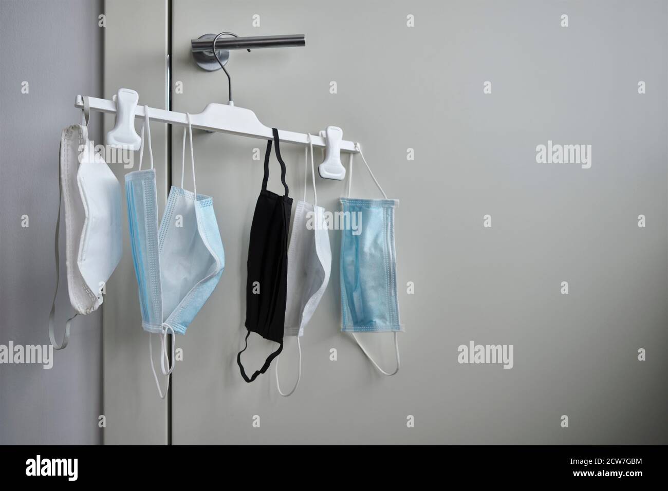 Different protective face masks hanging  with clothes Stock Photo
