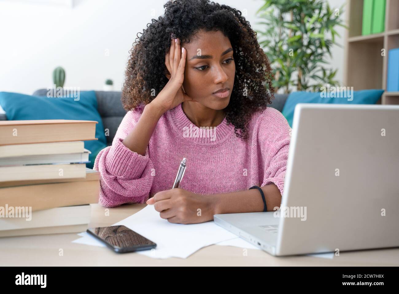 Happy young black woman studying at home Stock Photo - Alamy