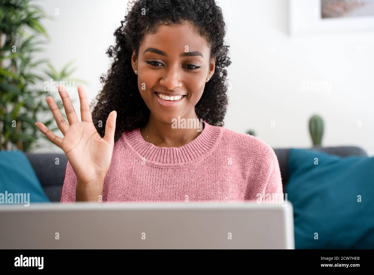 Cheerful afro woman using video chat call at home Stock Photo