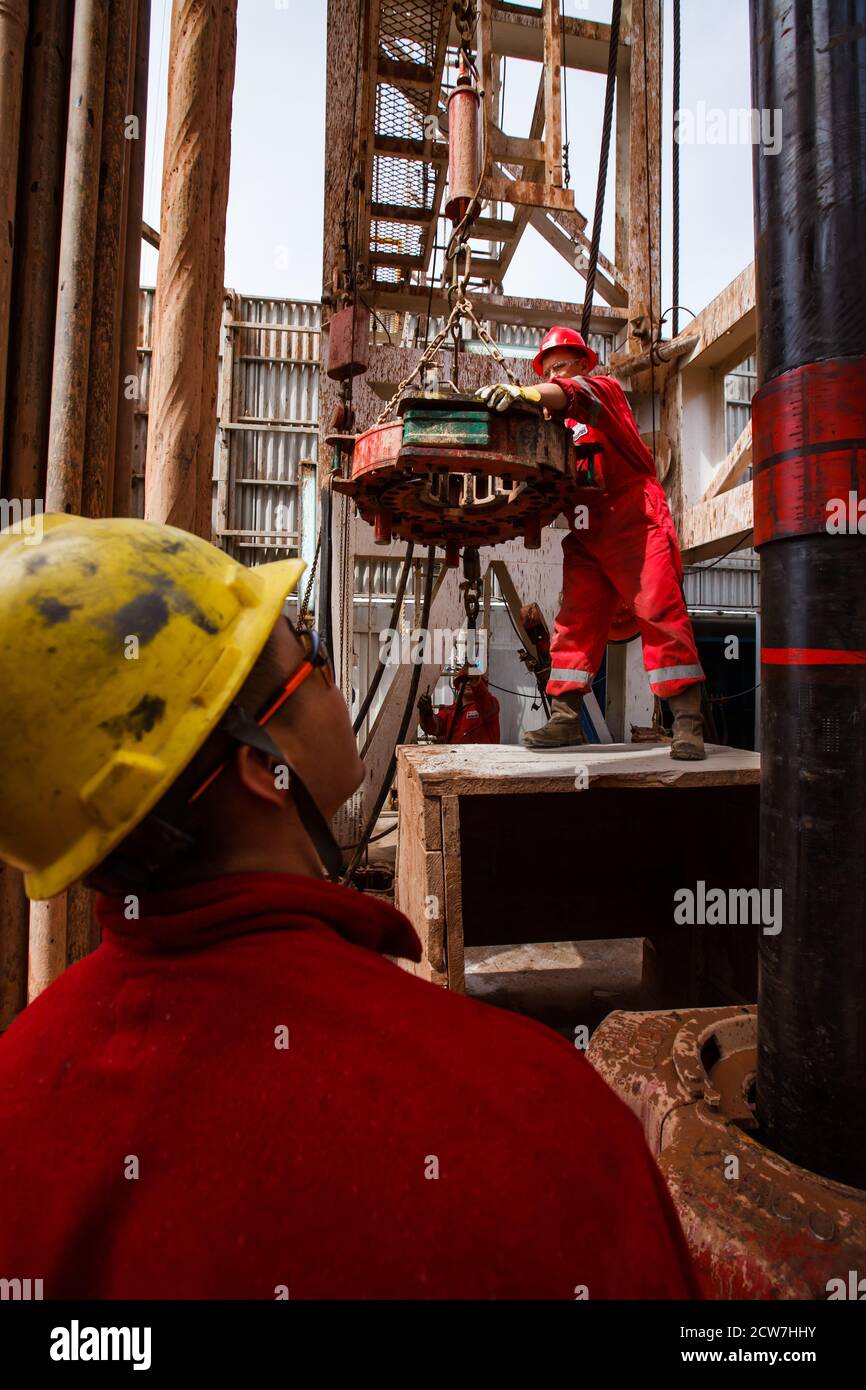 Oil drilling rig. Oil worker using electric clincher for drilling pipes.Zhaik-Munai oil deposit, Kazakhstan Stock Photo