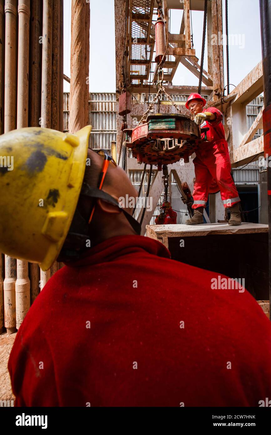 Oil deposit Zhaikmunai. Oil drilling rig. Workers using electric clincher for drilling pipes. Zhaik-Munai oil deposit, Kazakhstan Stock Photo