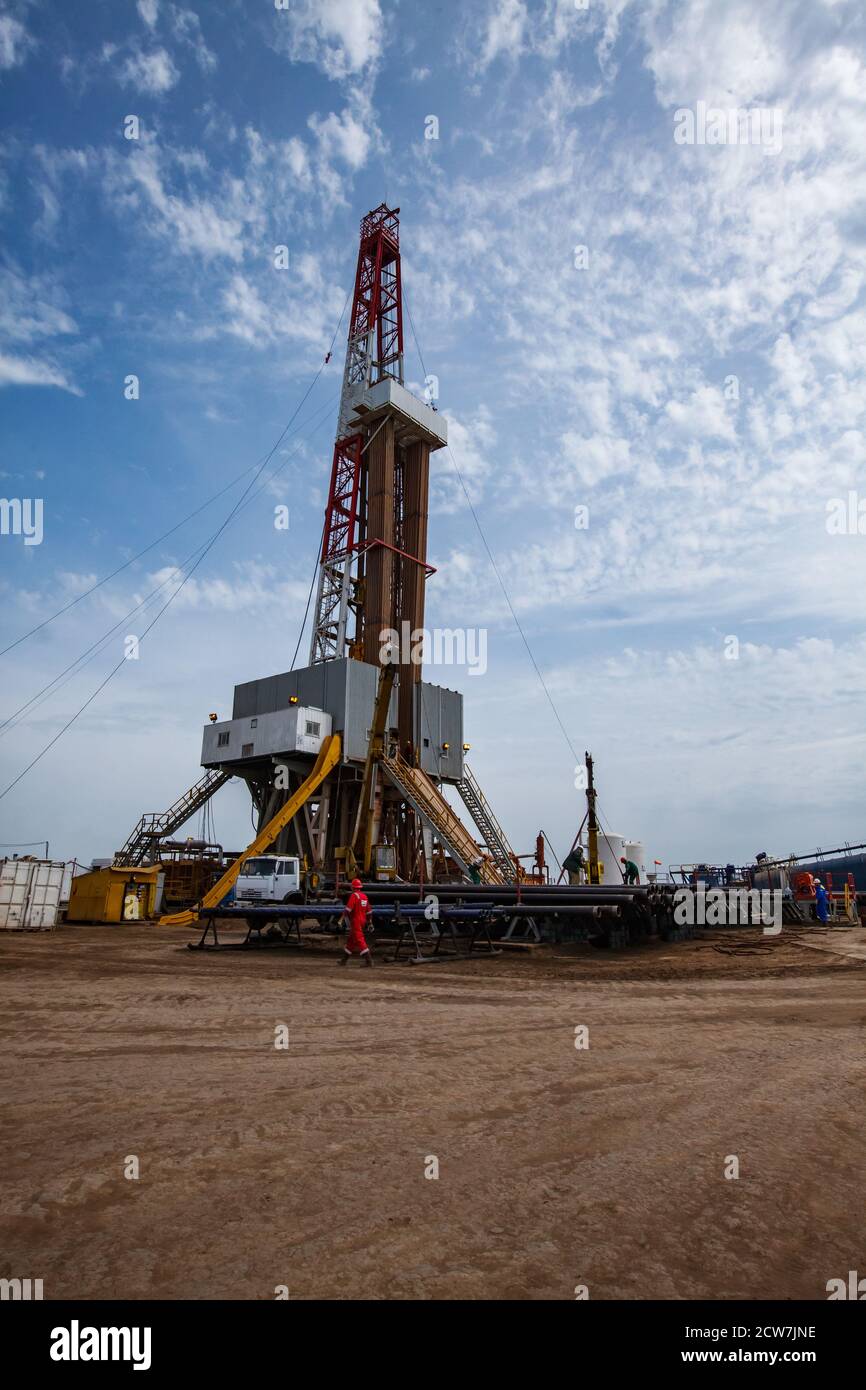 ZhaikMunai oil deposit, Kazakhstan. Oil drilling rig and oil worker in