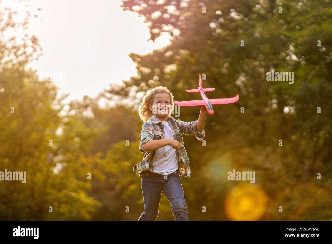 Little boy playing with toy plane in park Stock Photo