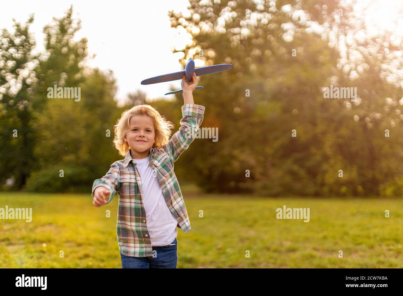 Little boy playing with toy plane in park Stock Photo