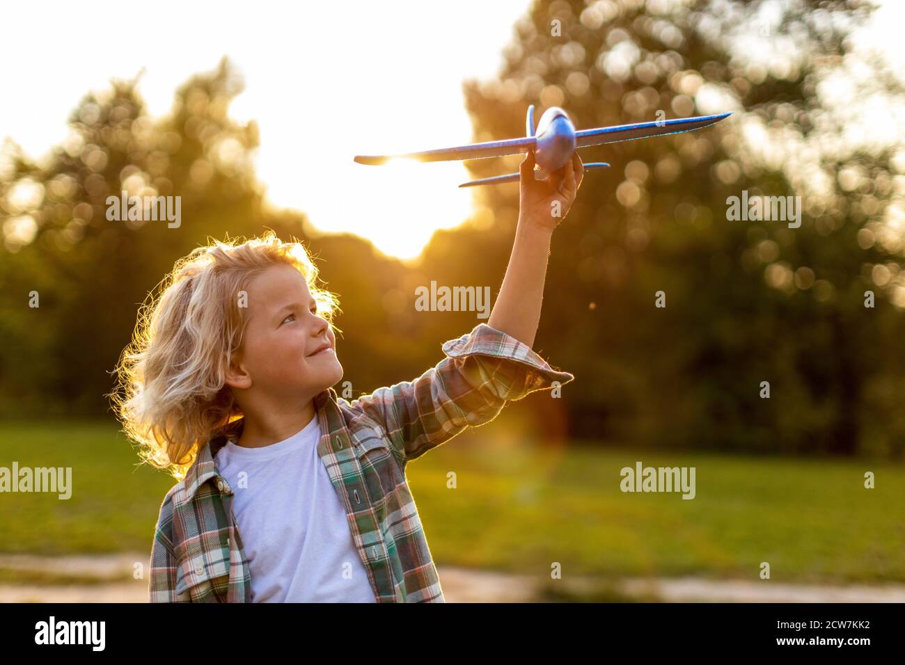 Little boy playing with toy plane in park Stock Photo