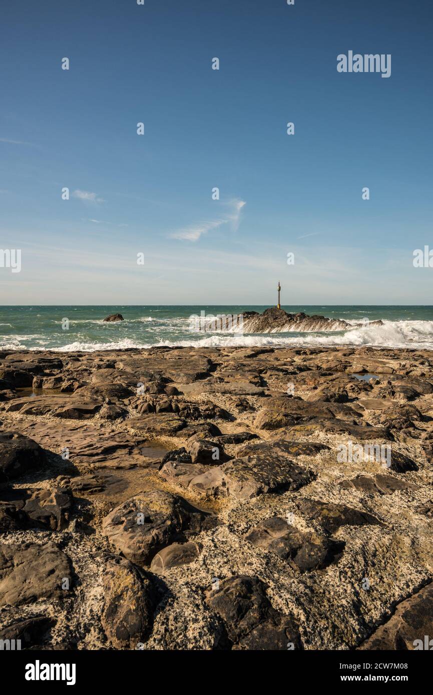 Portrait image of Barrel Rock at the end of Bude breakwater with Atlantic waves crashing against the rocks. Stock Photo