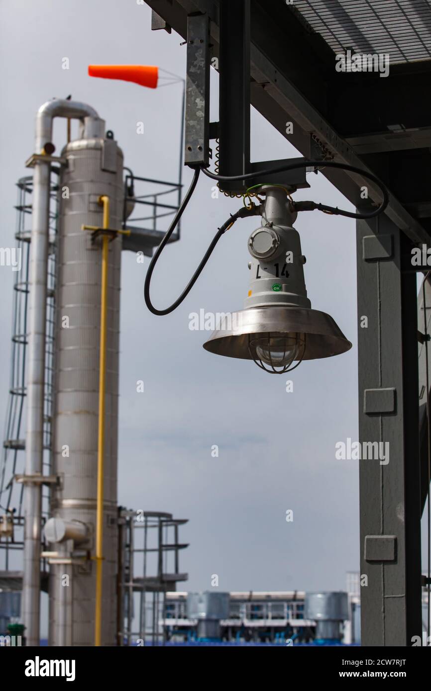 Oil deposit and refinery plant Zhaiyk-Munai, Kazakhstan. Safety technologies and equipment. Explosion-proof lamp. Weather vane on distillation tower. Stock Photo
