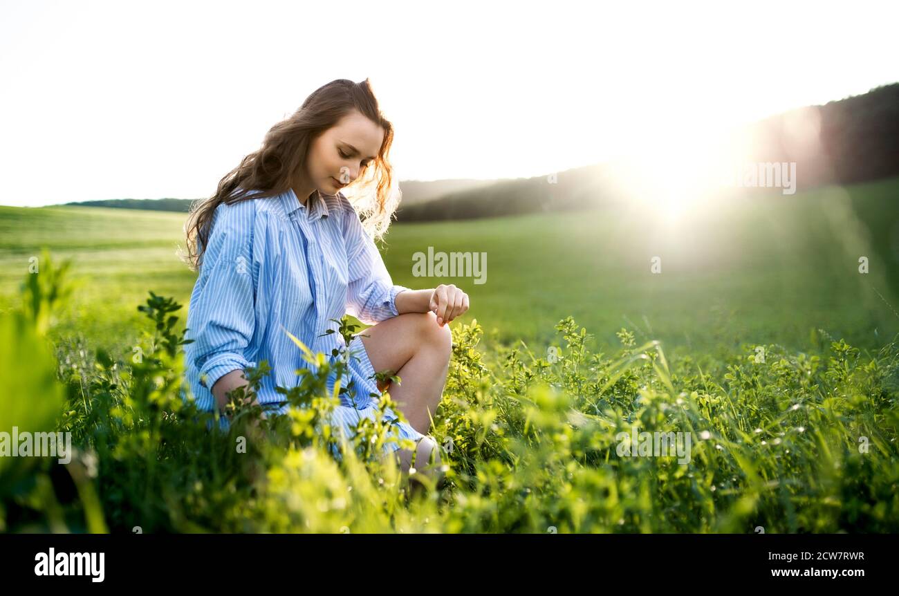 Portrait of young teenager girl outdoors in nature on meadow. Stock Photo