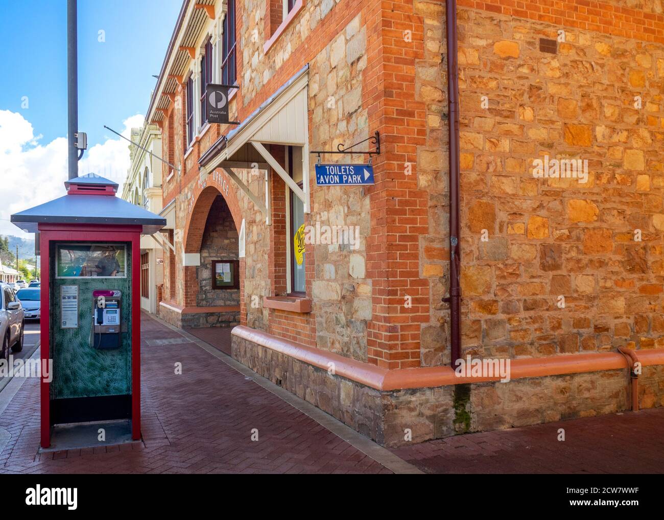 Telstra public red telephone booth in front of York Post Office stone