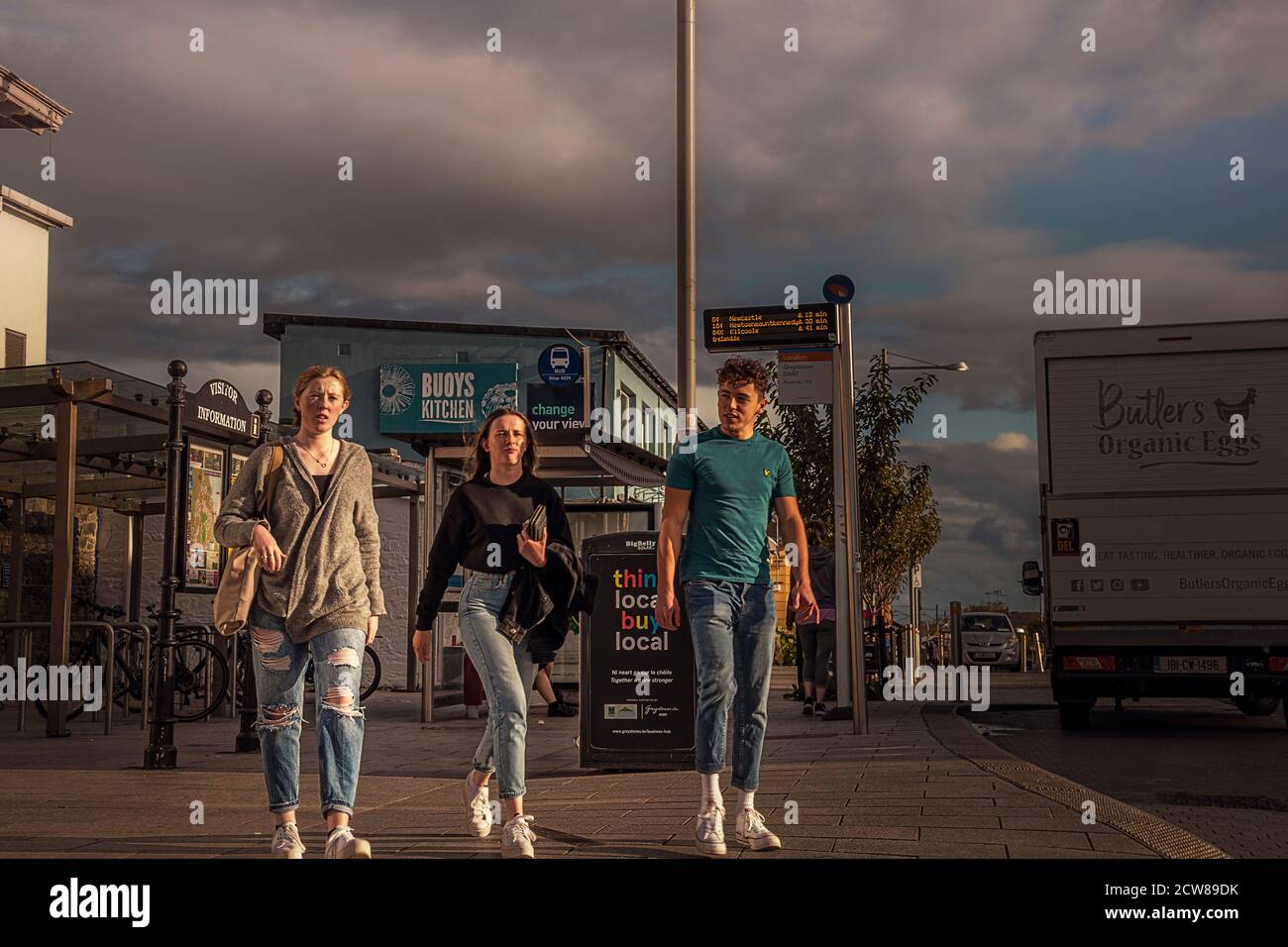 Everyday life. Girls and man walking towards the camera at Main street around train station. Greystones. Ireland. Stock Photo