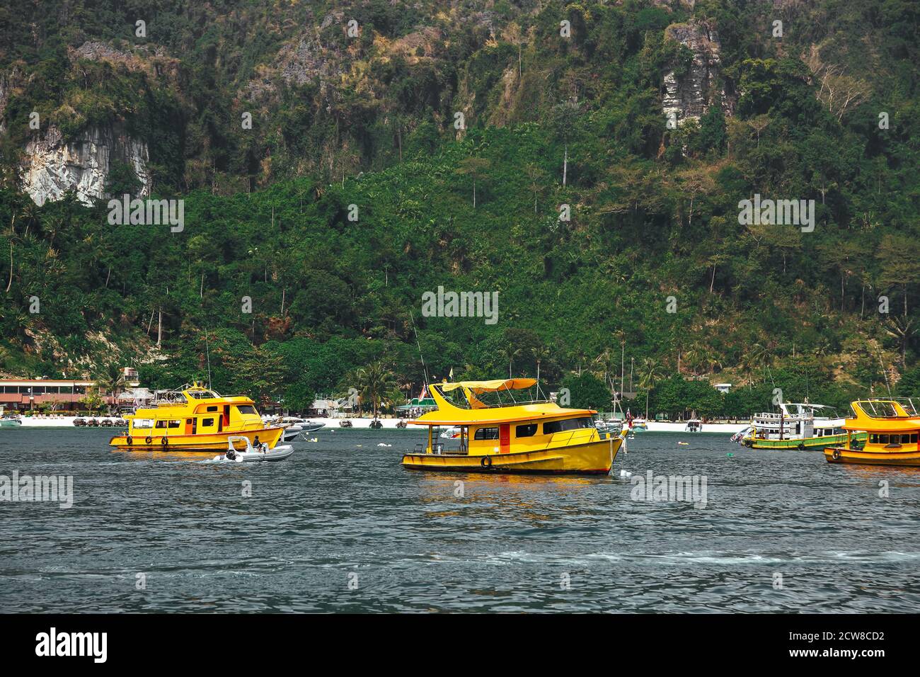 Three yellow passenger tourist speed boat, cruising near beach. Sea